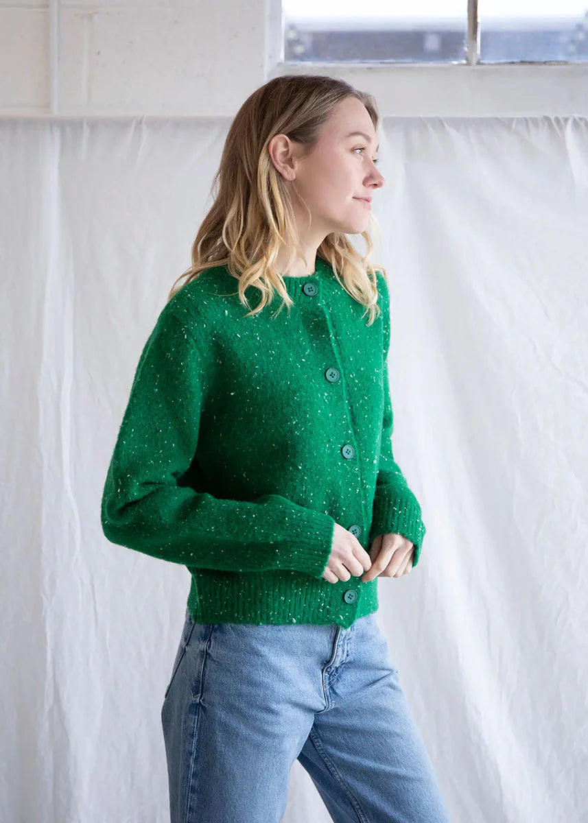 Green speckled knit button up cardigan featuring a relaxed fit and speckled yarn throughout for a charming holiday feel. 