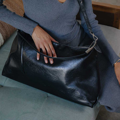 Spacious oversized leather shoulder bag in rich brown, featuring a smooth texture, sturdy straps, and a stylish, minimalist design perfect for everyday use.