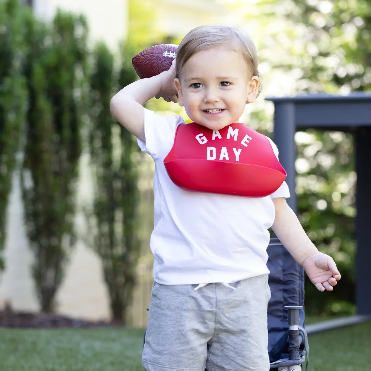 Red silicone baby bib with catch all pocket that says "game day"