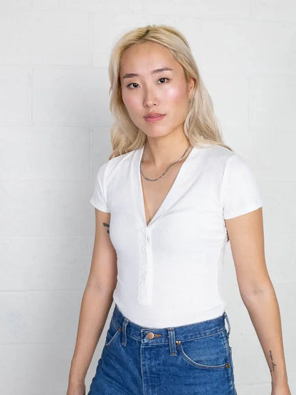 A v neck button up tee bodysuit in white for casual outfits.