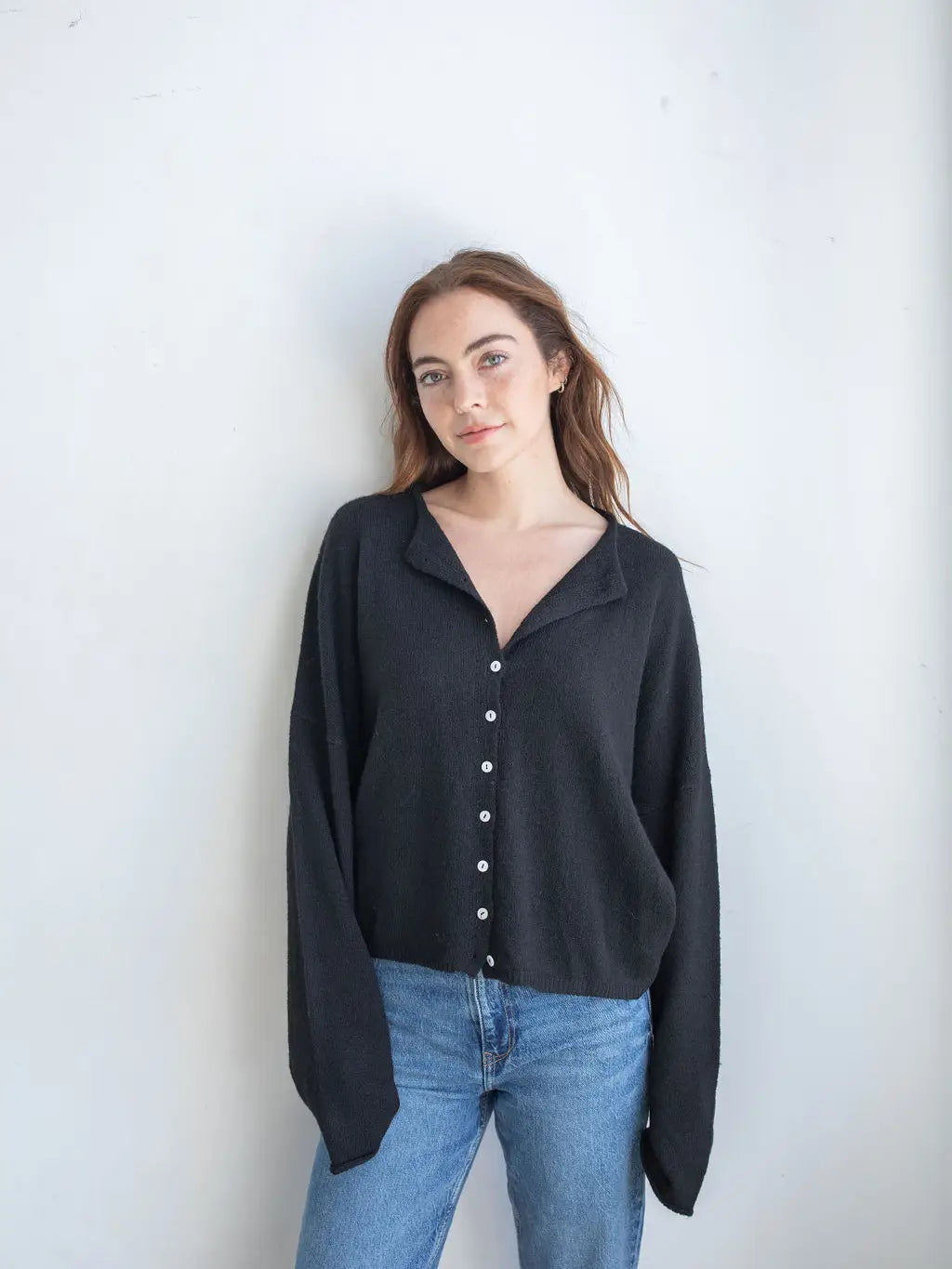 super soft loose fit cardigan in black, featuring small buttons lining the front offering a classic and casual style.