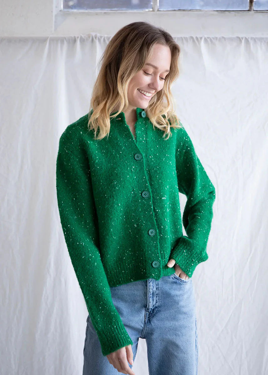 Green speckled knit button up cardigan featuring a relaxed fit and speckled yarn throughout for a charming holiday feel. 