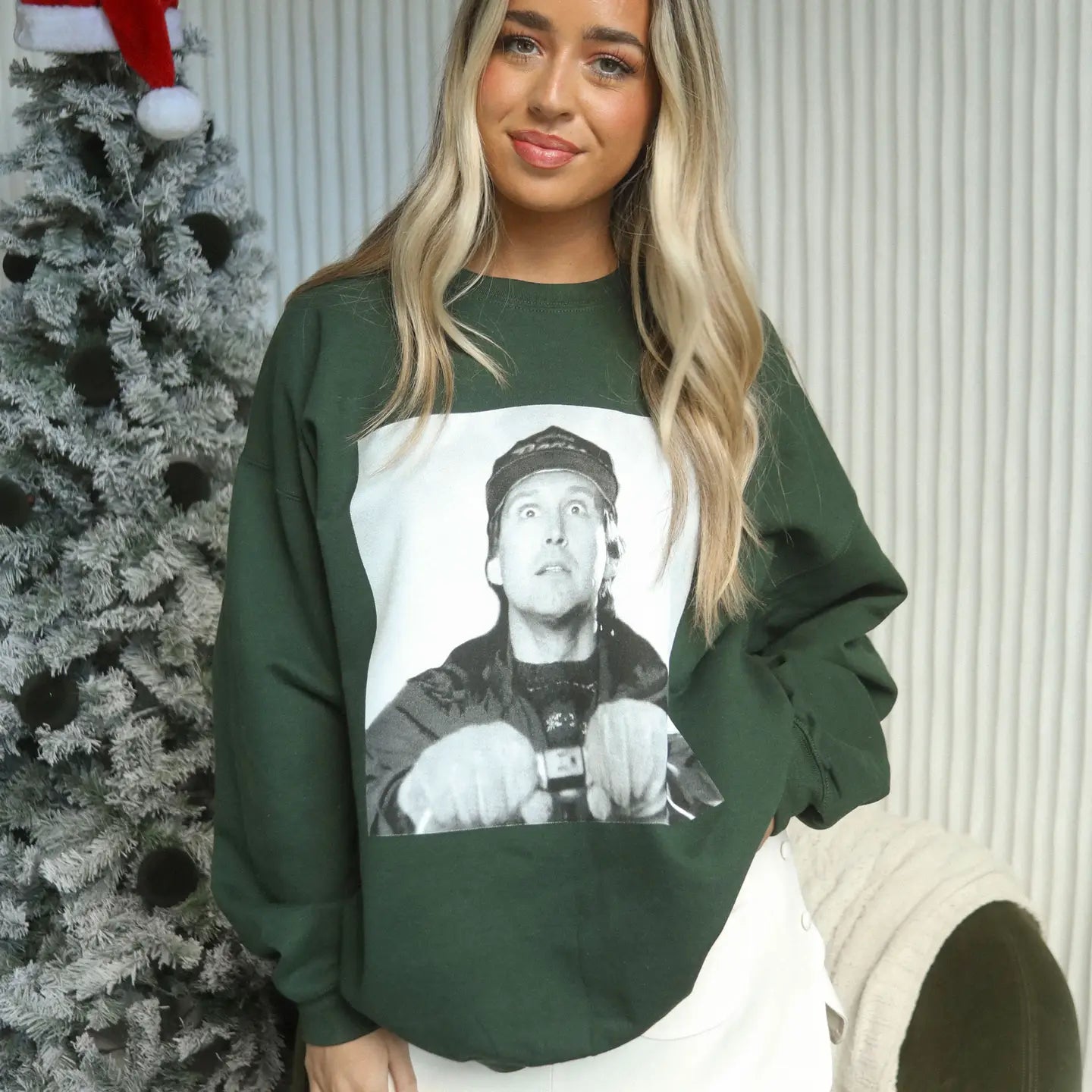 A classic holiday movie is now your new favorite sweatshirt featuring a extra large black and white photo of Clark Griswold holding the ends of the Christmas lights before he illuminates his home in all the Christmas glory.