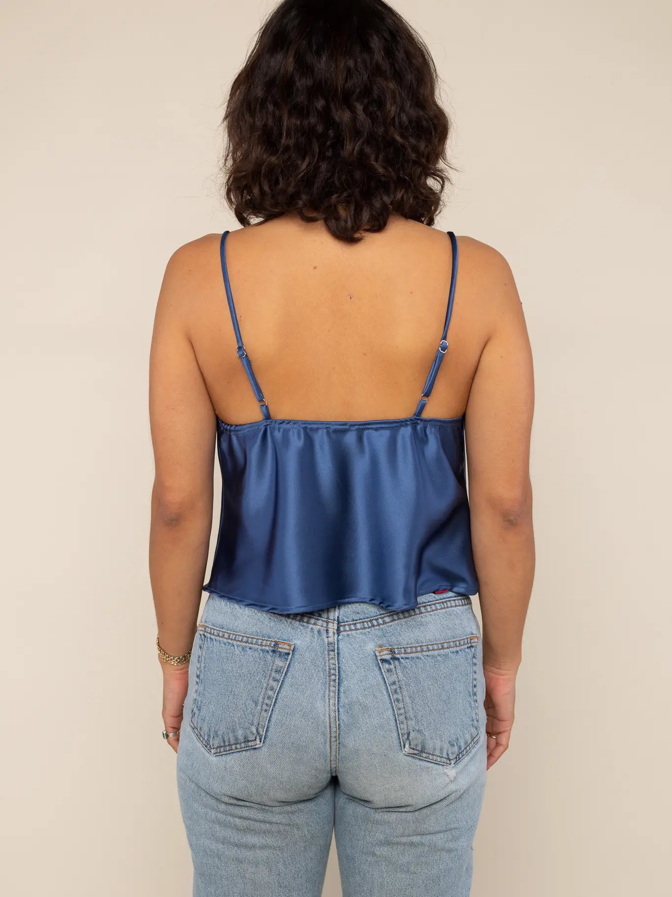 Satin tank blouse in dark navy with adjustable straps and cowl neck, and loose fitting throughout. Spaghetti straps and hitting right at the belly button for an elegant night out outfit.