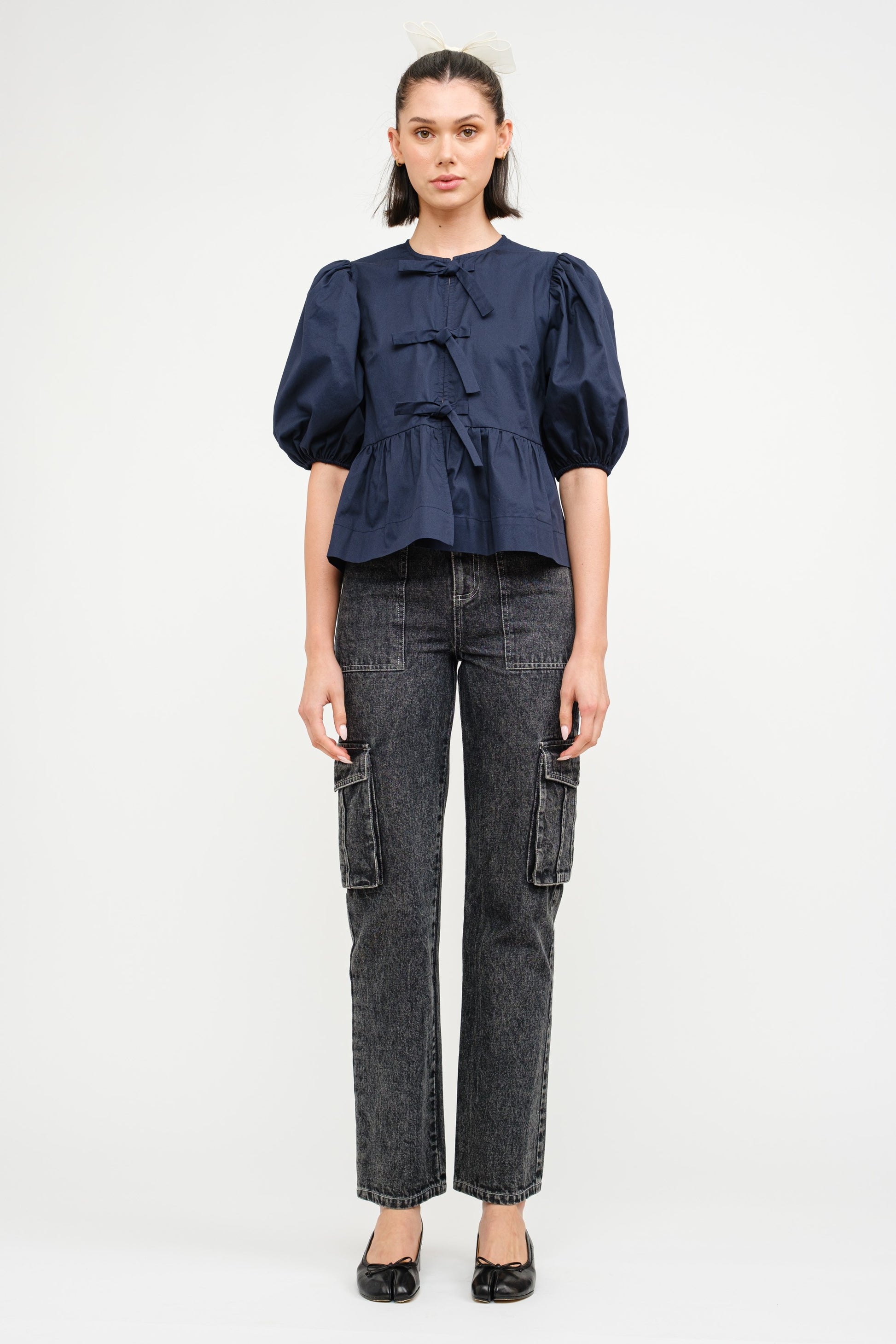 Dark navy blouse with three ties in the front and a slight puff short sleeve. 