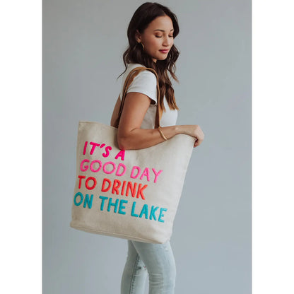 Extra large cream tote with colorful embroidered words "It's a good day to drink on the lake" included with magnetic zipper, double shoulder handle and interior pockets.