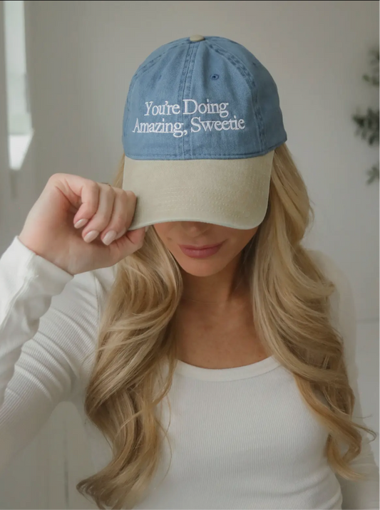 denim baseball cap hat with white letters that say "you're doing amazing sweetie" 